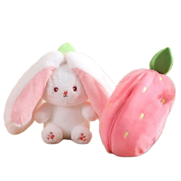 A plush toy set featuring a white bunny with long pink ears and a separate pink strawberry-shaped plush with green leaves.