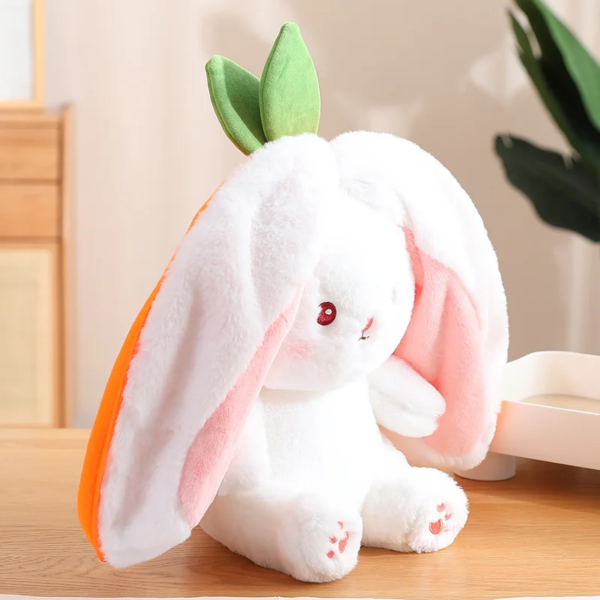 A plush white rabbit toy with long pink-lined ears, green leaf-like details atop its head, and red eyes, sitting on a wooden table in a home setting.